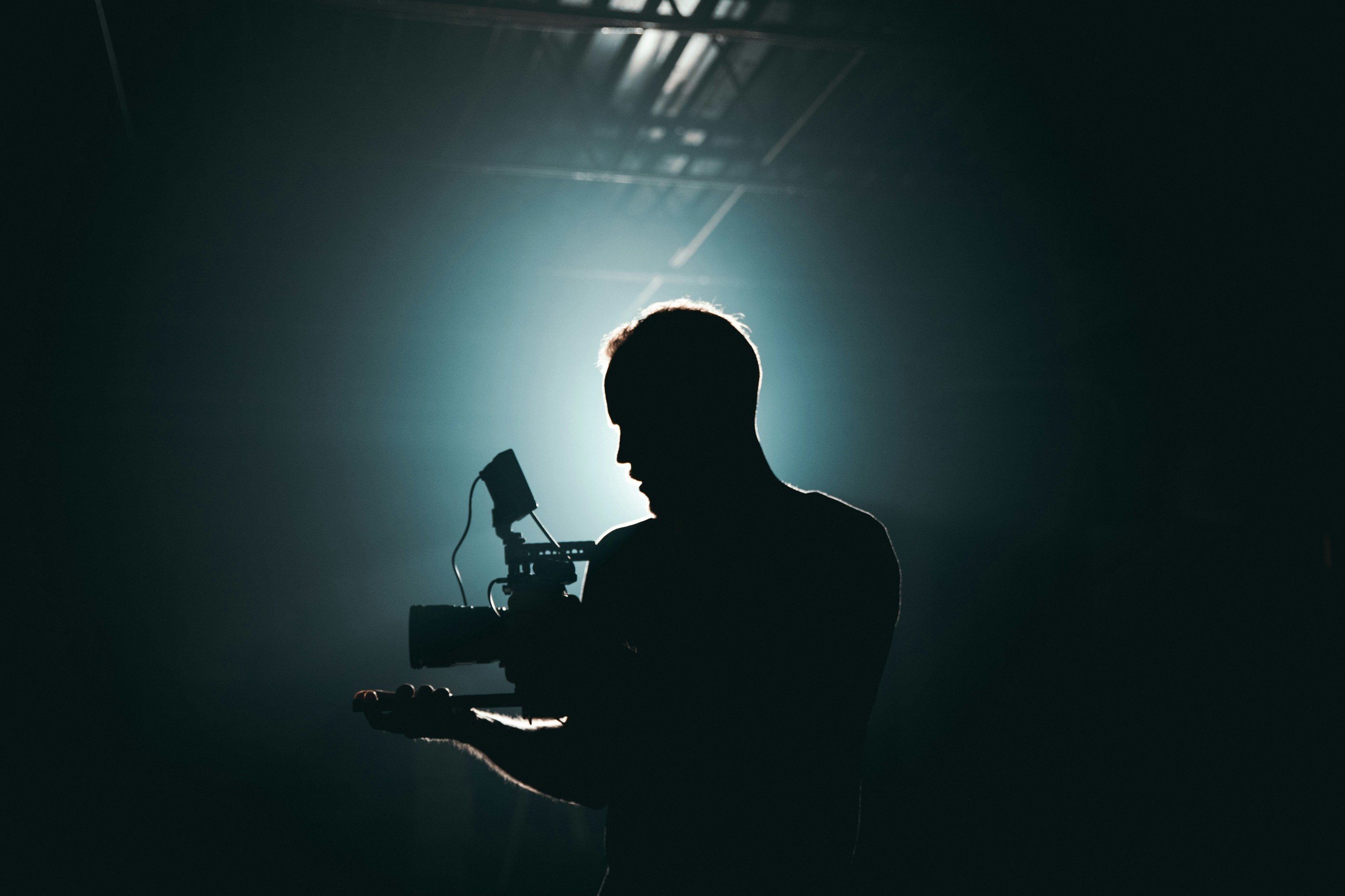 Silhouette of a man with a film camera in front of a light.